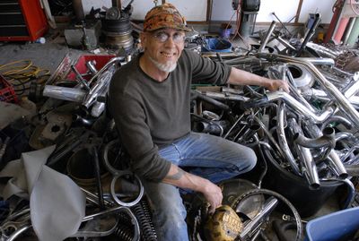 “These are my art supplies,” said Spokane Valley sculpturer Al Blum, refering to the pile of old motorcycle parts piled in his garage. At top, Blum’s “Flaming Breasted Horned Eagle Owl” is perched on a post-and-beam archway over his driveway. It is made out of old motorcycle parts, and lights up at night. (J. BART RAYNIAK / The Spokesman-Review)