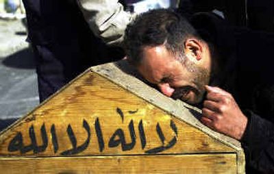 
A man cries over the coffin of his brother outside Baghdad's Yarmouk hospital Friday. The man was one of at least 16 police officers killed in an attack on a police station in Baghdad.
 (Associated Press / The Spokesman-Review)