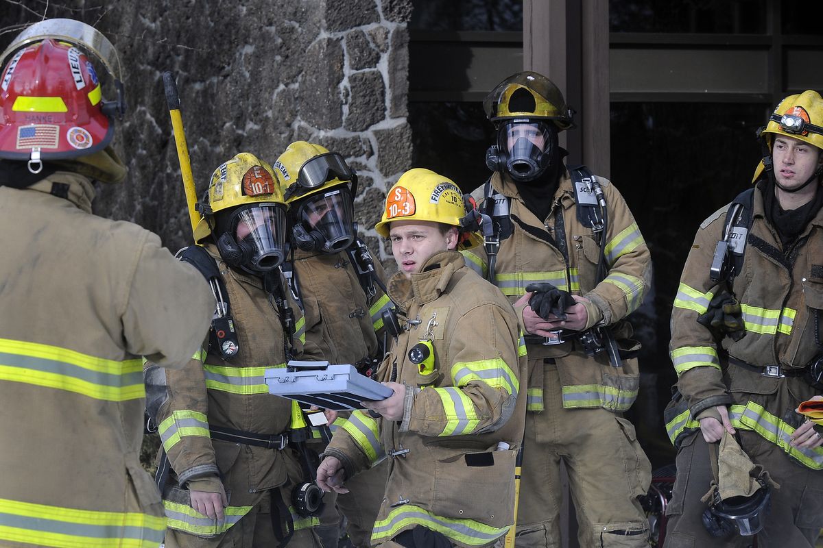 Firefighters prepare to enter the administration wing of the Seventh-day Adventist headquarters to help prevent fire from spreading from the main entrance Sunday, Dec. 28, 2008. (Dan Pelle / The Spokesman-Review)
