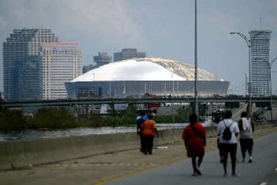 
People walk toward the Louisiana Superdome seeking shelter on Wednesday. 
 (Associated Presss / The Spokesman-Review)