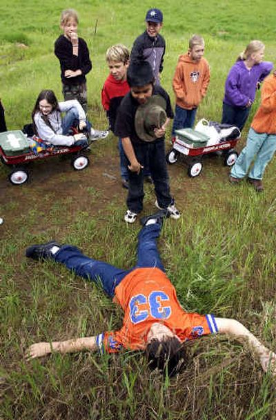 
Borah Elementary fourth-grader Jesse Lionberger plays dead along the 