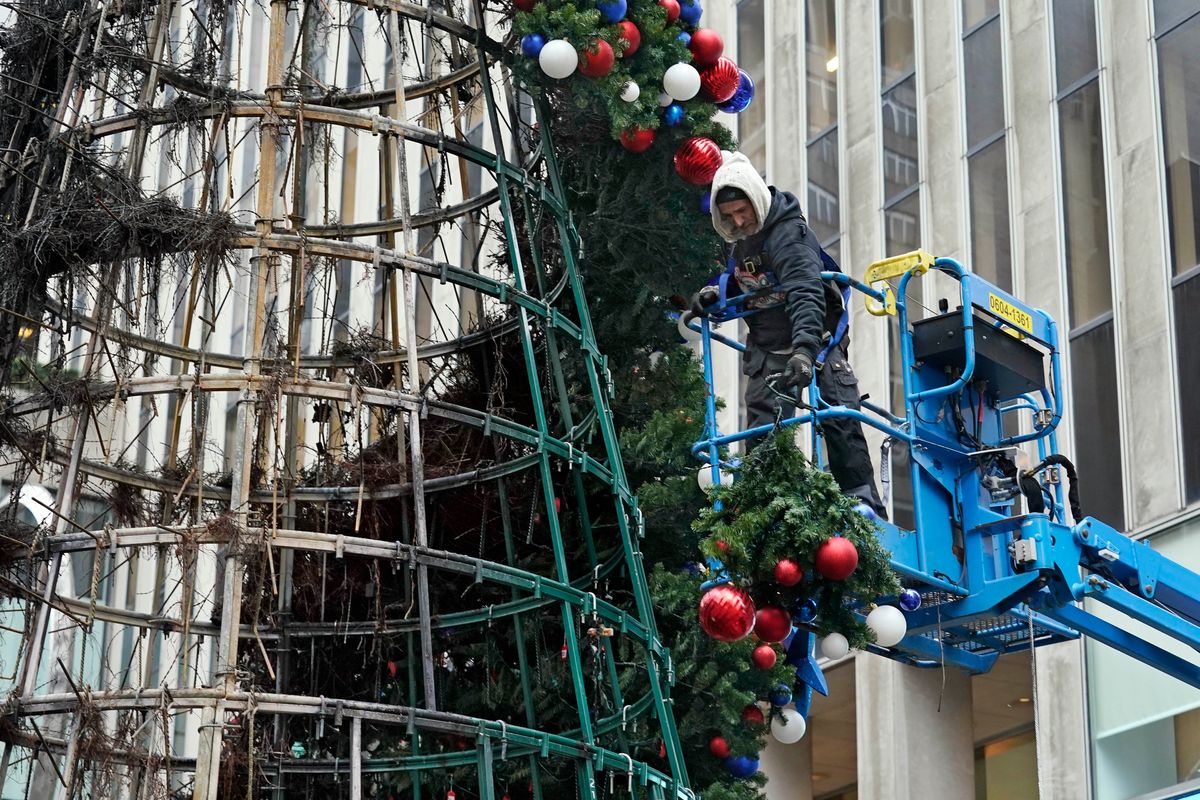 A worker disassembles a Christmas tree outside Fox News headquarters, in New York, Wednesday, Dec. 8, 2021. Police say a man is facing charges including arson for setting fire to a 50-foot Christmas tree in front of Fox News headquarters in midtown Manhattan. The tree outside of the News Corp. building that houses Fox News, The Wall Street Journal and the New York Post caught fire early Wednesday.  (Richard Drew)
