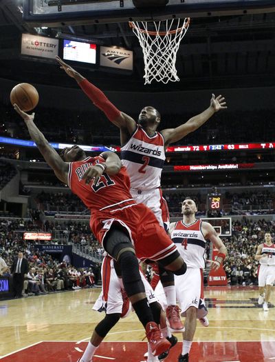 John Wall, right, contests the shot of Chicago’s Jimmy Butler. (Associated Press)