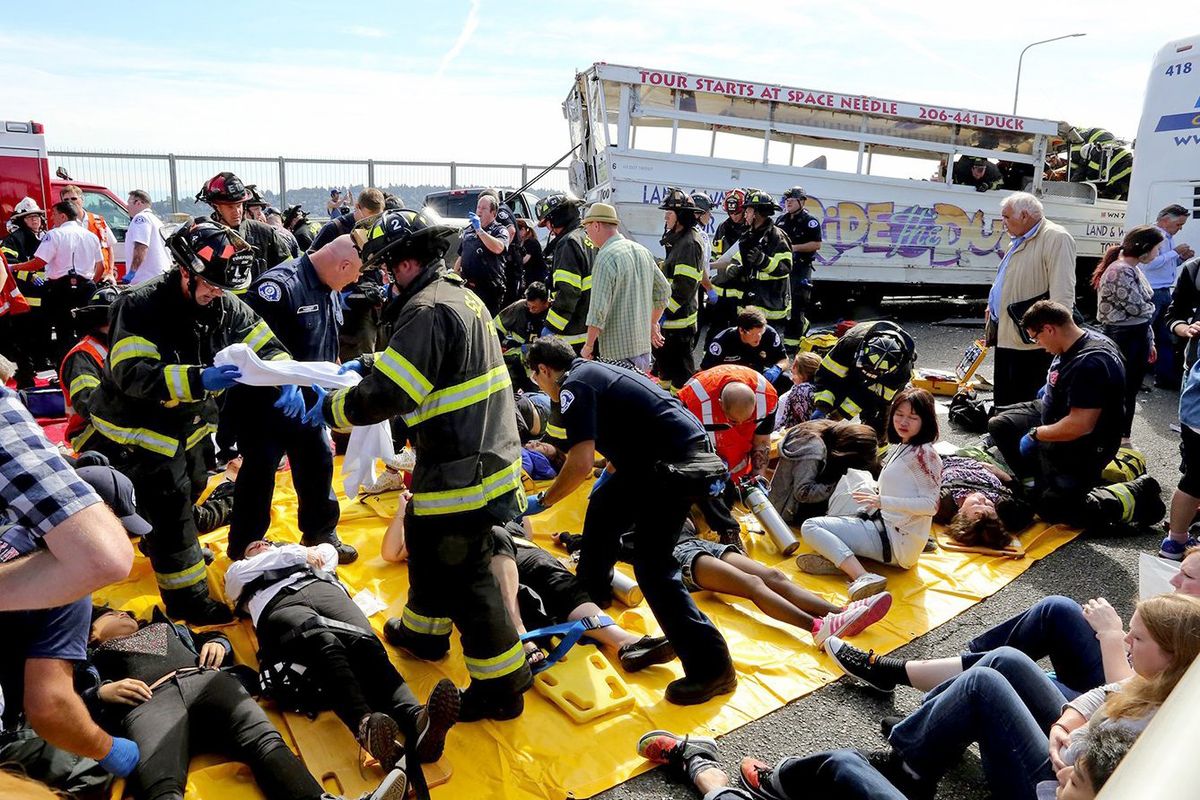 Emergency personnel tend to victims of the collision, including several foreign college students, on the Aurora Bridge in Seattle. (Associated Press)