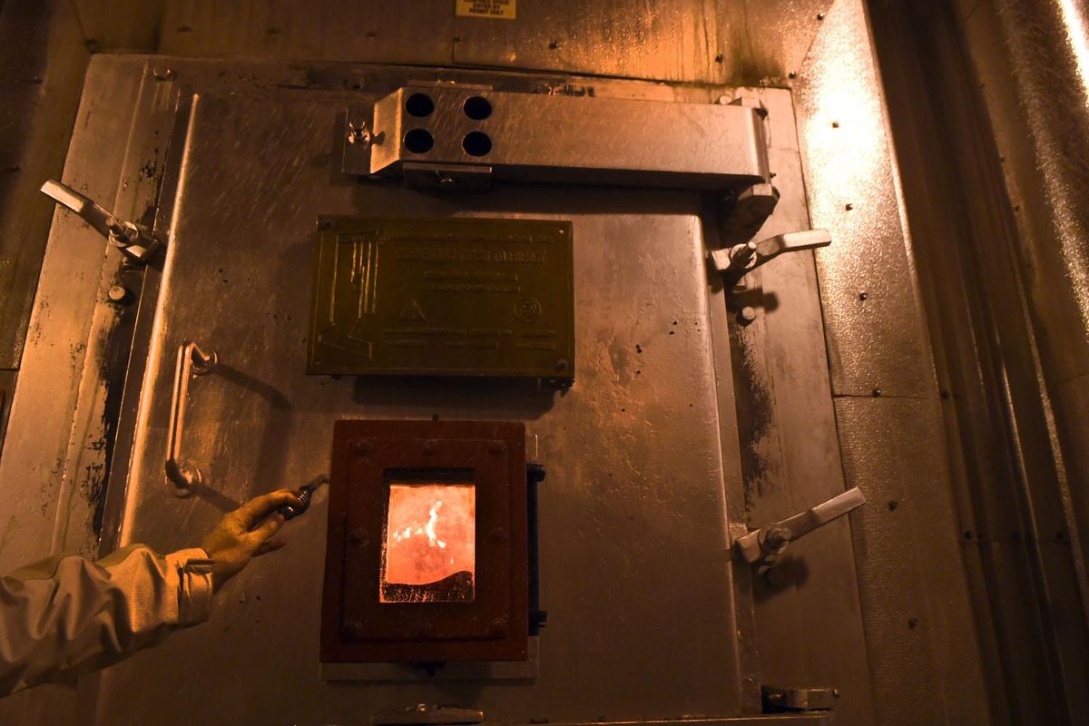 Kris Major holds the handle to the viewing door of one of the incinerators at the Waste-to-Energy Plant in Spokane on Tuesday, Dec.13, 2016. Spokane police, along with Seattle police and other agencies, incinerate drugs and guns at the facility. (Kathy Plonka / The Spokesman-Review)