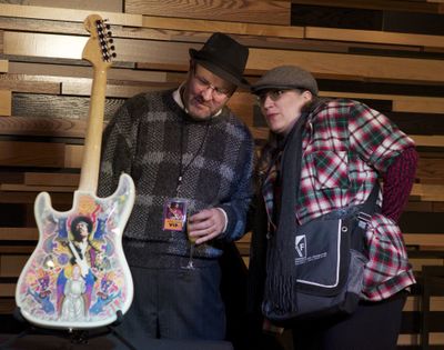 Creative collaboration: James Weaver and Lucy Wilma, both of Seattle, get a close look at a Fender Stratocaster with artwork by Alan Aldridge during the launch of the Jimi Hendrix Signature Series Edition 29 merchandise including T-shirts and pins at the Hard Rock Cafe Seattle on Thursday. Fifteen percent of the sales of the merchandise will benefit the Fender Music Foundation and the Jimi Hendrix Park Foundation. The artwork for the guitar began as a collaboration between artist Alan Aldridge and Jimi Hendrix in 1970.