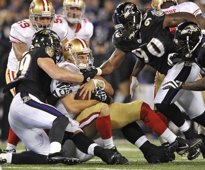 San Francisco’s Alex Smith, center, is wrapped up by Baltimore’s Paul Kruger, left, and Pernell McPhee. (Associated Press)