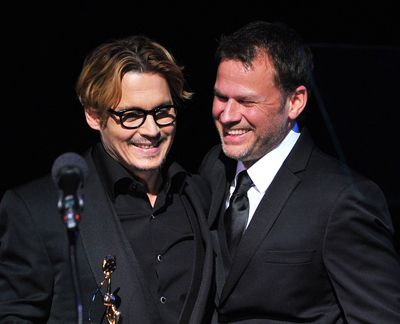Johnny Depp, left, and Joel Harlow share a laugh at the Make-Up Artists and Hair Stylists Awards. (Associated Press)