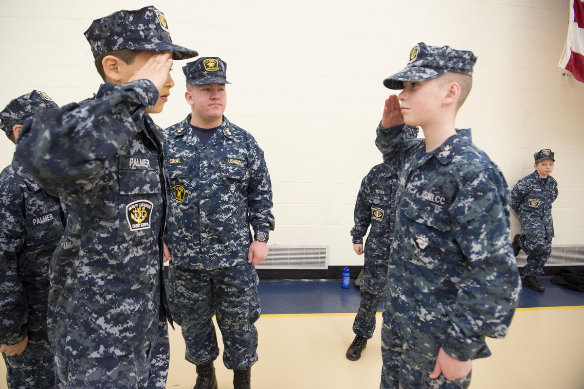Gilbert Palmer, left, exchanges salutes with Gavin Farnsworth, right, during drill time at the U.S. Naval Reserve Center in Spokane on Saturday, March 17, 2018. It was drill weekend for the Sea Cadets, a group that trains young people in the skills of the Navy. In the center is Midshipman Hunter Cihal, a cadet until he turned 19, is a volunteer leader with the Sea Cadets. (Jesse Tinsley / The Spokesman-Review)
