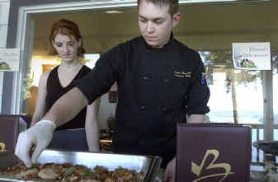 
Chef Adam Hegsted, right, and Jessica Crump of Brix restaurant present a platter of appetizers at the food fair sponsored by Cancer and Community Charities. 
 (Jesse Tinsley / The Spokesman-Review)