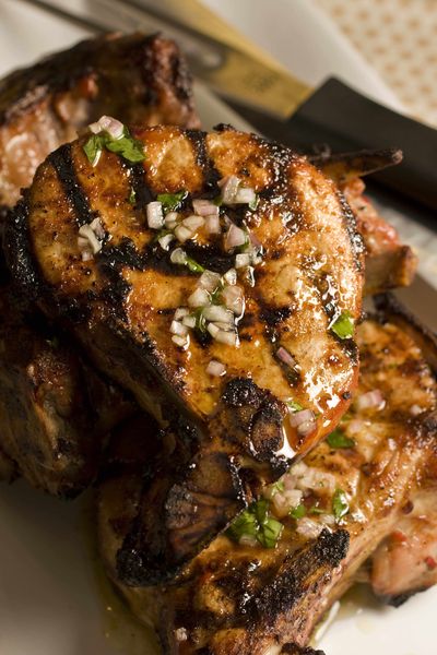 Spice-crusted Thick Rib Pork Chops are among the featured dishes in Adam Perry Lang’s new cookbook, 