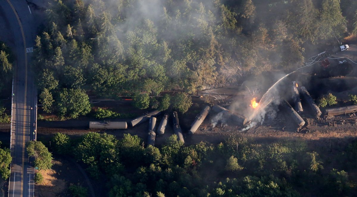 An oil train burns near the Oregon town of Mosier after derailing Friday, June 3, 2016. (Alan Berner / The Seattle Times via AP)