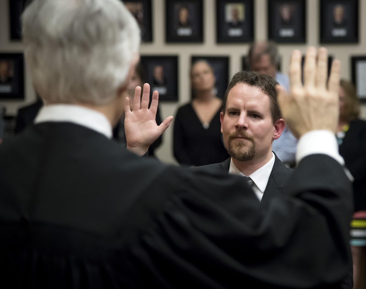 Superior Court Judge Michael Price (back to camera) swears in new Spokane County Superior Court Judge Tony Hazel during an investiture  Friday, May 5, 2017, at the Gonzaga University Law School. (Colin Mulvany / The Spokesman-Review)