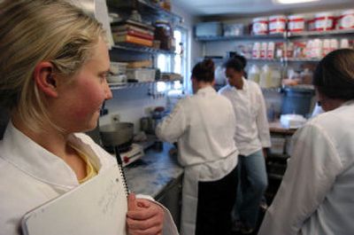 
Eli Penberthy, left, watches as a group of local high school students try their luck in the kitchen of Luna Restaurant last year. 
 (Christopher Anderson / The Spokesman-Review)