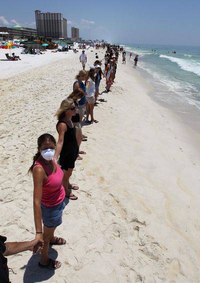Hundreds line up as part of the Hands Across the Sand event in Pensacola Beach, Fla., on Saturday.  (Associated Press)