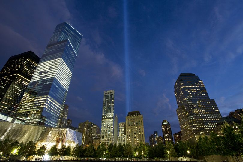 In this Monday, Sept. 8, 2014 photo, the Tribute in Light rises behind buildings adjacent to the World Trade Center in New York. The art installation consists of 88 searchlights aiming skyward in two columns, in memory of the former twin towers. Four World Trade Center is at left. Thirteen years after 9/11 forever changed the New York skyline, officials say developments at the World Trade Center are on track and on budget. (Mark Lennihan / Associated Press)