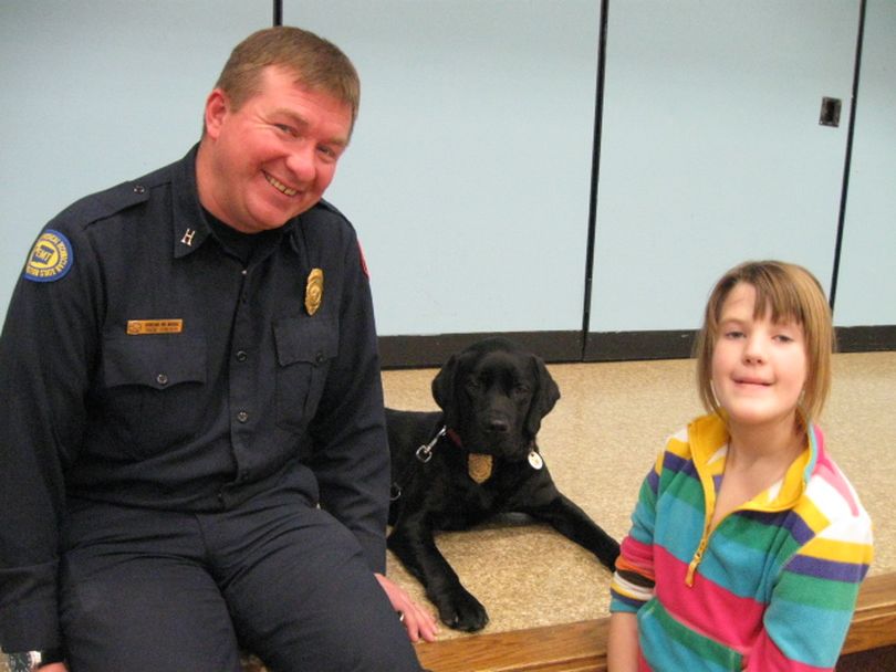 Mako, the Spokane Valley Fire Department arson dog, poses with fire investigator Rick Freier and a student at the Sunrise Elementary Science Fair this week. (Photo courtesy Spokane Valley Fire Department)