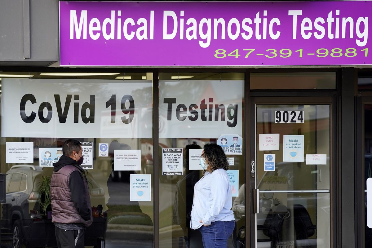 Nn Exam Corp Lab employee, right, wears a mask as she talks with a patient lined up for COVID-19 testing Oct. 21, 2020, in Niles, Ill.  (Nam Y. Huh)