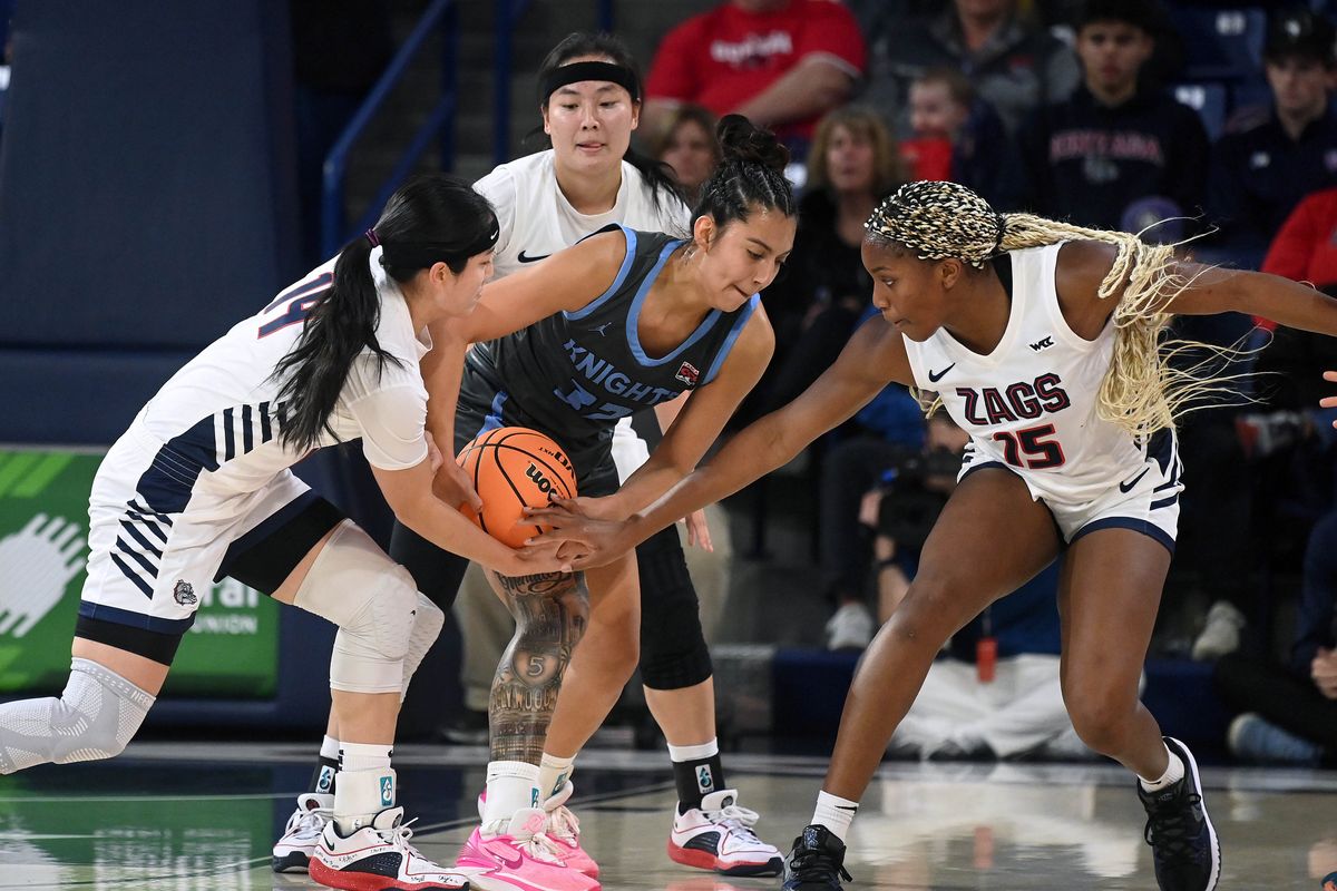 All hands lead to a jump ball, left to right, Gonzaga guard Kaylynne Truong (14), Warner Pacific forward Larsa Guzman (32) and Gonzaga forward Yvonne Ejim (15) during the first half of a NCAA college basketball game, Thursday, Nov. 2, 2023, in the McCarthey Athletic Center.  (COLIN MULVANY/THE SPOKESMAN-REVIEW)