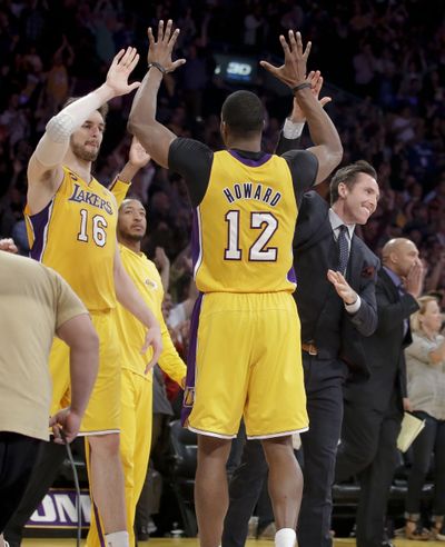 Los Angeles Lakers' Pau Gasol, left, Dwight Howard, center, and Steve Nash celebrate Lakers’ 99-95 overtime win. (Associated Press)