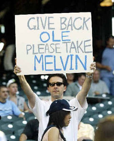 
A fan holds up a sign lamenting Melvin's hiring and Olerud's release.
 (Associated Press / The Spokesman-Review)