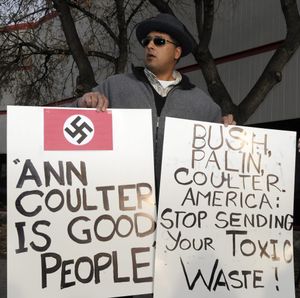 A man holds up signs outside the venue where American conservative pundit Ann Coulter gives a talk on Political Correctness, Media Bias and Freedom of Speech in Calgary, Canada  on Thursday March 25, 2010. (Larry Macdougall / The Canadian Press)