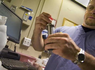 
Nuclear medicine technician Chad Young works with an isotope sample Monday at Deaconess Medical Center. 
 (Christopher Anderson / The Spokesman-Review)