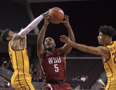 Washington State guard Milan Acquaah, center, goes up for a basket as Southern California guard Derryck Thornton, left, and forward Bennie Boatwright defend during the first half of an NCAA college basketball game Sunday, Dec. 31, 2017, in Los Angeles. (Kyusung Gong / Associated Press)