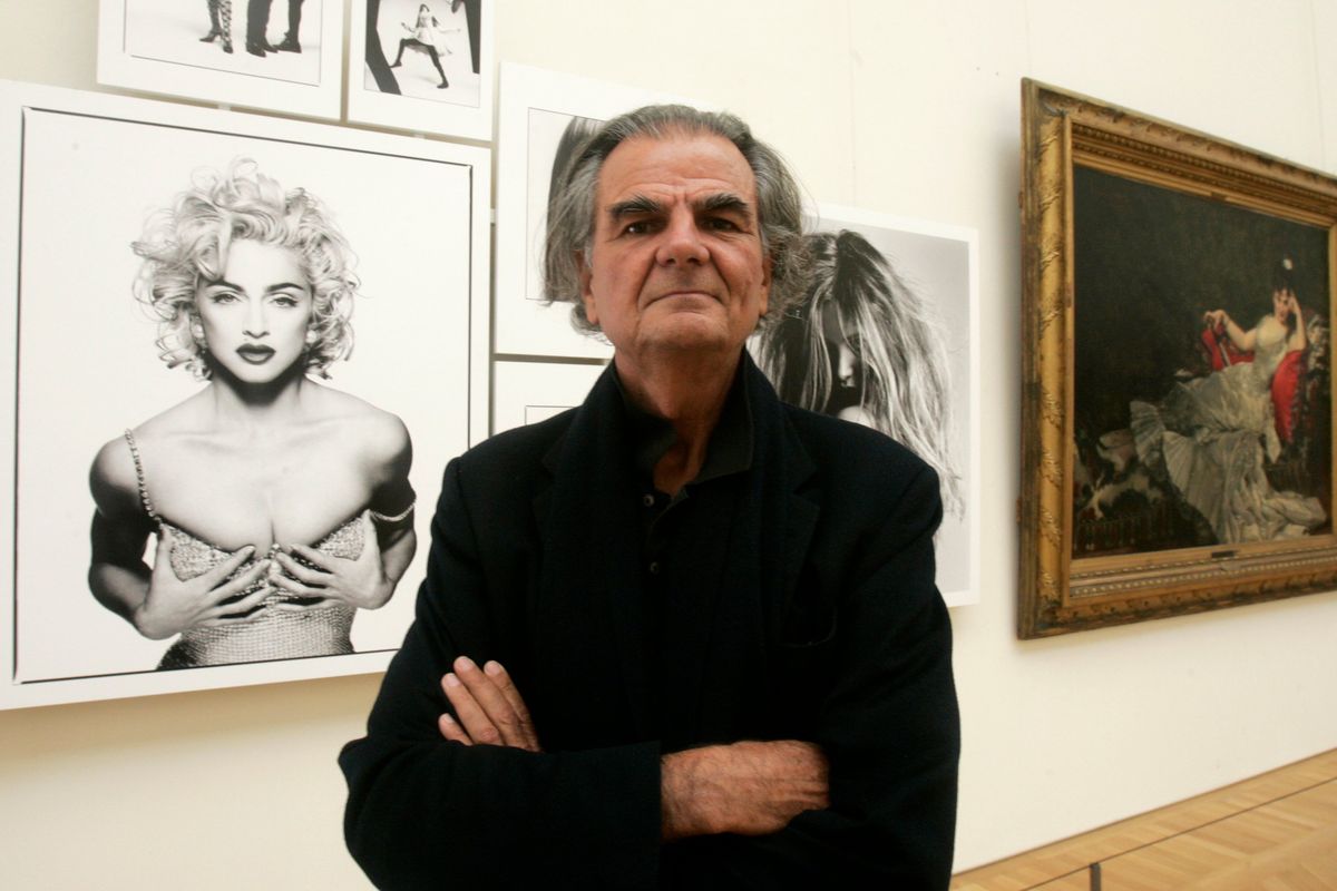 Photographer Patrick Demarchelier appears in front of his photograph of Madonna at the Petit Palais in Paris, Sept. 26, 2008. Demarchelier, the French-born photographer known for his high fashion images of top models and celebrities, including Princess Diana, has died at age 78.  (Michel Euler)