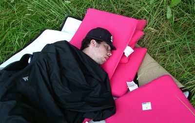 Burglary suspect Kyle Burress sleeps on pillows and pads allegedly stolen from storage containers at a nearby Fred Meyer  July 9. Police photographed Burress before waking and arresting him. (Associated Press / The Spokesman-Review)