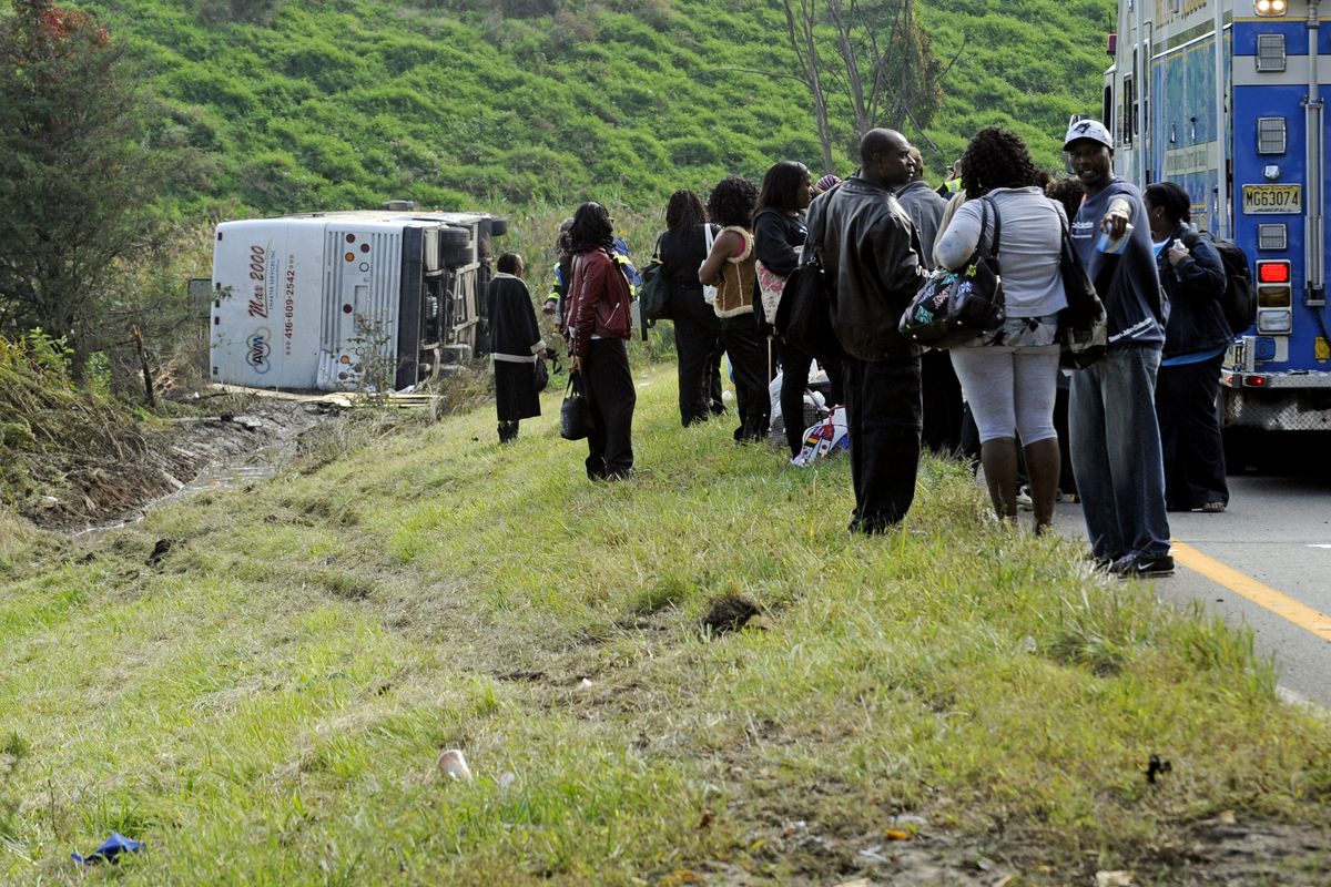 Passengers look on after their bus overturned in a ditch at an exit ramp off Route 80 in Wayne, N.J. Saturday, Oct. 6, 2012. The chartered tour bus from Toronto carrying about 60 people overturned on an interstate exit ramp. Three people have been taken to hospital with non-life-threatening injuries. (Bill Kostroun / Fr51951 Ap)