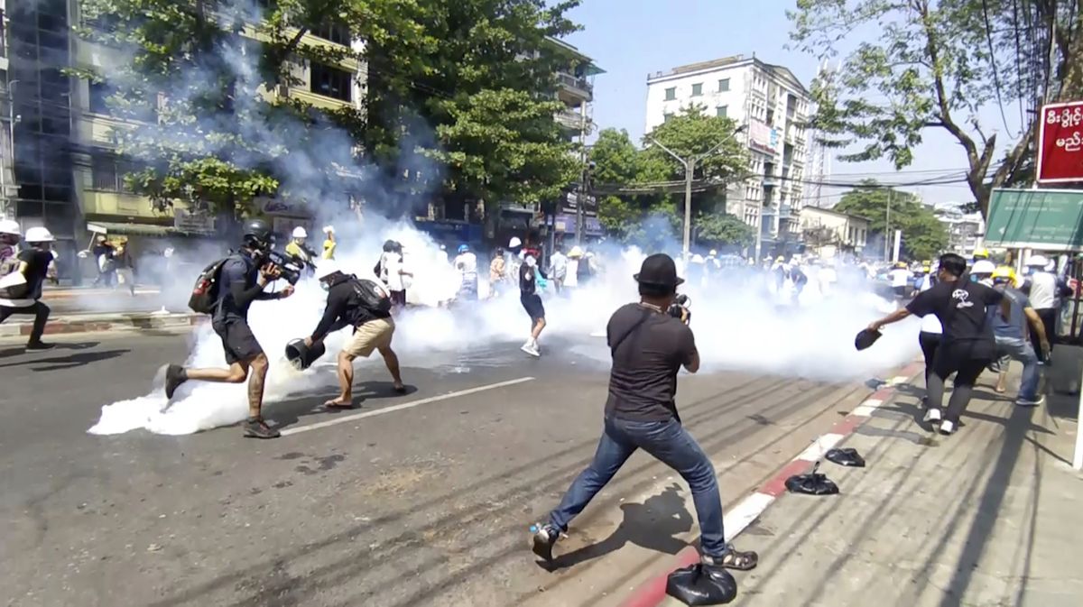 In this image from a video, anti-coup protesters run away from tear gas launched by security forces in Yangon, Myanmar Monday, March 1, 2021. Defiant crowds returned to the streets of Myanmar