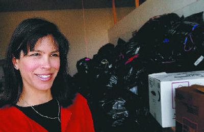 
Karen Thurston, the founder of Community Green Cross, stands near several bags of collected clothes. 
 (Kathy Plonka / The Spokesman-Review)
