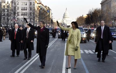 President Barack Obama and first lady Michelle Obama walk down Pennsylvania Avenue en route to the White House on Tuesday.  (Associated Press / The Spokesman-Review)