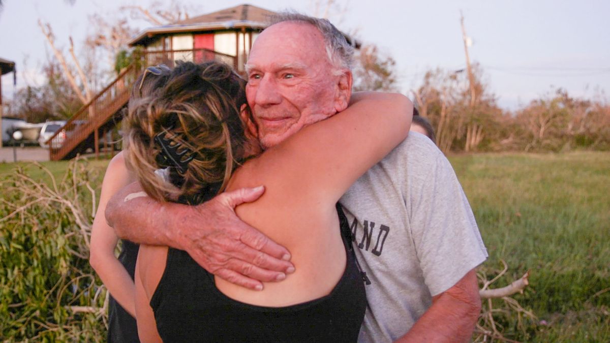 Richard "Rocky" Lane hugs his neighbor Nicole Sheaer, 32, before leaving his Pine Island home on Saturday, Oct. 1, 2022, after Hurricane Ian devastated the area.    (Jennifer Glenfield/Tampa Bay Times/TNS)