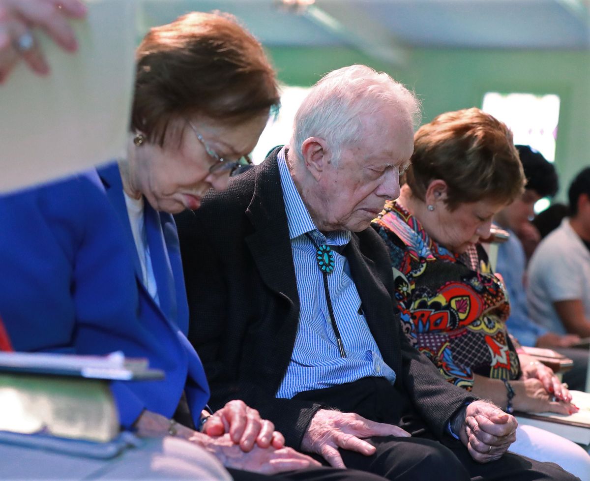 Former President Jimmy Carter, center, and his wife Rosalynn, left, bow in prayer along with members and visitors during the worship service at Maranatha Baptist Church on June 9, 2019, in Plains, Ga.  (Curtis Compton/The Atlanta Journal-Constitution/TNS)