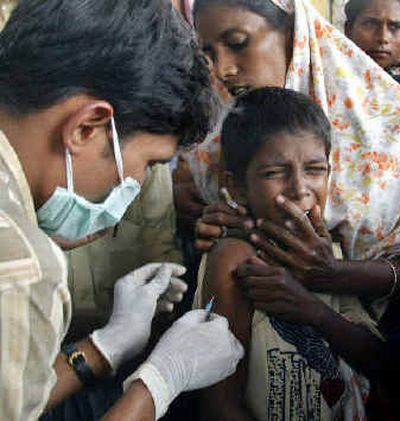 
A boy reacts as he receives a tetanus shot from a medic at a relief camp at Nagore, in the southern Indian state of Tamil Nadu, on Tuesday. Officials said at least 58,000 people were killed in 12 countries after massive tsunami waves smashed coastlines on Sunday. 
 (Associated Press photos / The Spokesman-Review)