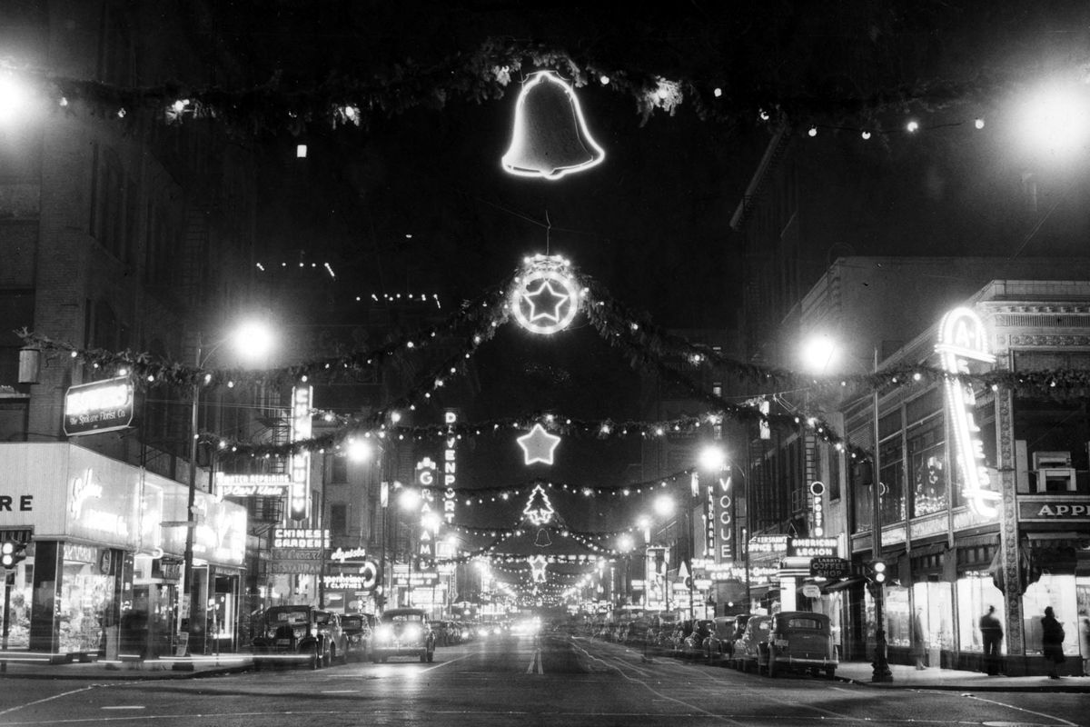 December 1948: Looking west on Sprague Avenue from Howard Street, the streets of downtown Spokane are decorated for the holiday season. Each year, the glittering lights and decor were financed by consortiums of retail businesses eager to lure shoppers to the downtown area. But the first Christmases in Spokane were simple. (Photo Archive)