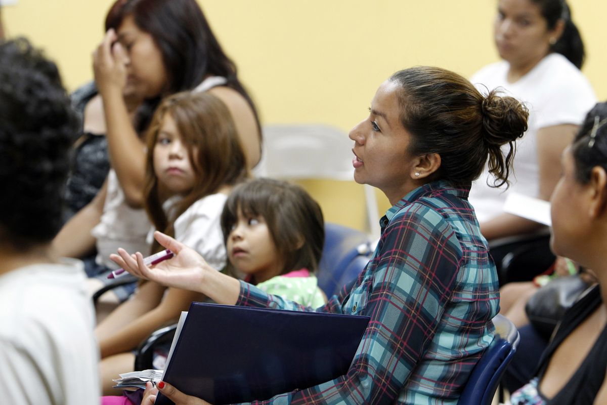 Participants and their children, most born in the United States, attend an orientation seminar for illegal immigrants, to determine if they qualify for temporary work permits, at the Coalition for Humane Immigrant Rights of Los Angeles (CHIRLA), in Los Angeles, Thursday, Sept. 20, 2012. Schools and consulates have been flooded with requests for documents since President Barack Obama�s administration said many young illegal immigrants may be eligible for two-year renewable work permits. The new policy has left schools and consulates scrambling for quick fixes ranging from new online forms, reassigned workers and extended hours. (Reed Saxon / Associated Press)