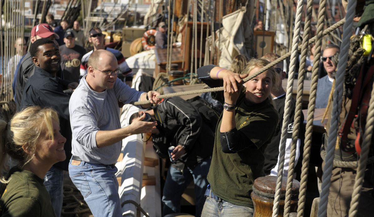 HMS Bounty deckhand Anna Sprague, right, leads crew from the U.S. Navy Virginia class attack submarine USS Mississippi to raise the Bounty’s sails during a one-day cruise off the coast of New London, Conn., on Thursday. The U.S. Coast Guard rescued 14 members of the Bounty’s crew off the North Carolina coast Monday. One member was found later, and the captain was missing as of Monday night. (Associated Press)