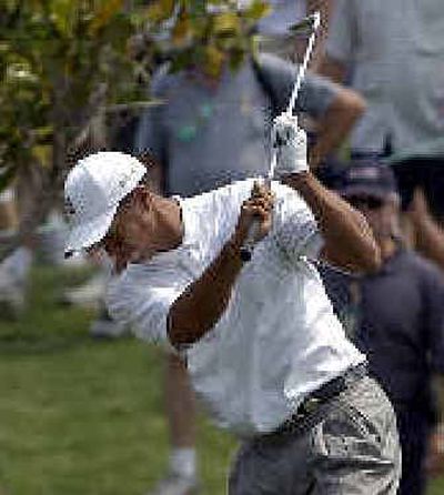 
Tiger Woods slams his club after his fairway shot on the 4th hole. 
 (Associated Press / The Spokesman-Review)