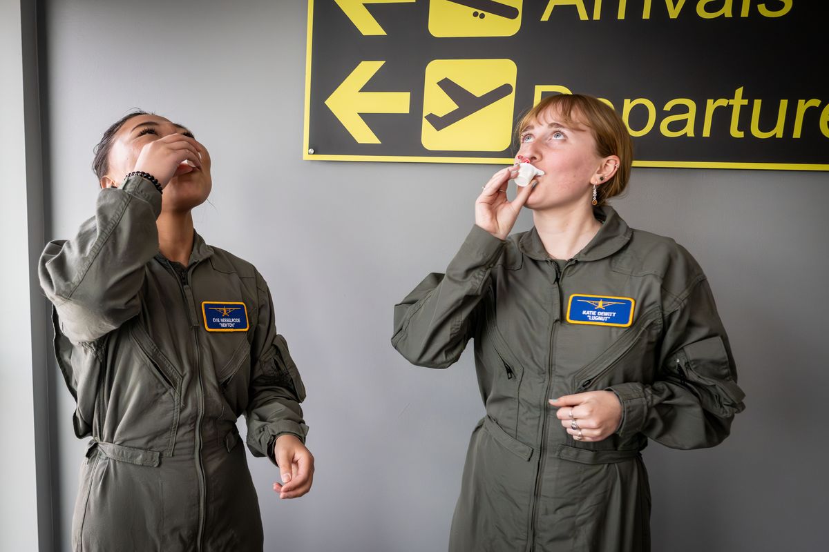 Before each flight with instructors, AFJROTC cadets Evelyn Nesselrode,18, and Katie Dewitt, 16, do a shot of nondairy creamer Friday before heading to the tarmac to do their pre-flight preparations at Felts Field.  (COLIN MULVANY/The Spokesman-Review)