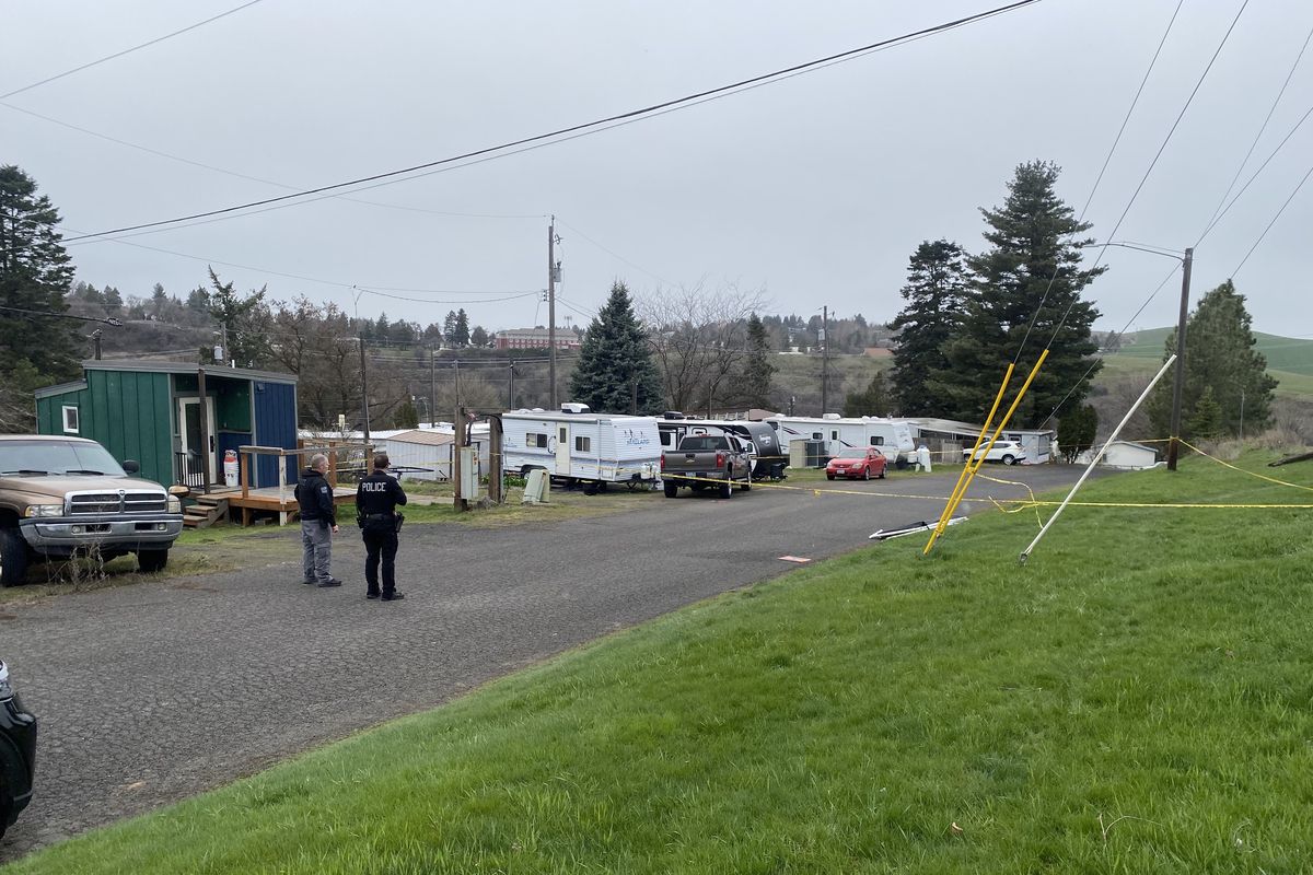 Investigators are seen standing just outside the area where a woman was found dead in Military Hill, Pullman, on March 27, 2024.   (Sabrina Vachris)
