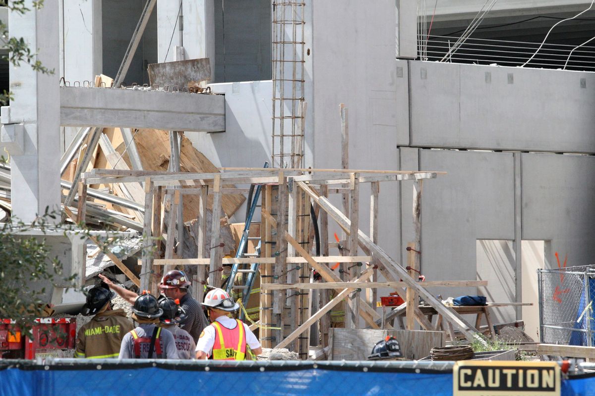 Miami-Dade Fire-Rescue workers view the West Campus parking lot of the Miami-Dade College in Doral, Fla., on Wednesday, Oct. 10, 2012. A section of the parking garage under construction collapsed Wednesday, trapping some workers and shaking the buildings around it. (Hector Gabino / El Nuevo Herlad)