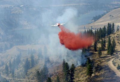 
A P-3 tanker plane drops fire retardant over a spot fire that erupted across from the main Harker Canyon fire on Thursday afternoon. The fire, located seven miles northeast of Davenport and burning between 1,500 and 2,000 acres, threatened about 30 homes along Moccasin Bay, on the south shore of the Spokane Arm of Lake Roosevelt.
 (The Spokesman-Review)
