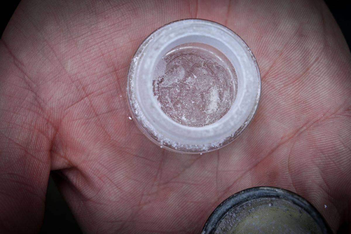 A fentanyl user in Spokane holds a small container with the drug in powder form.  (COLIN MULVANY/THE SPOKESMAN-REVIEW)