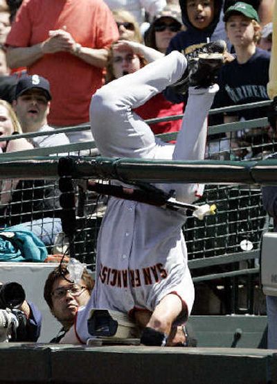 
Giants first baseman Travis Ishikawa plunges upside down after snagging a foul ball. 
 (Associated Press / The Spokesman-Review)