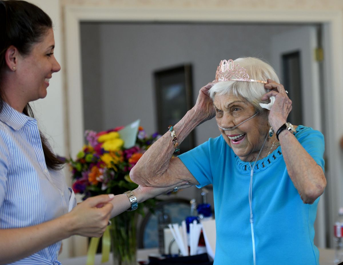 Nita Jensen, 100, adjusts her tiara with help from her granddaughter, Lauren Itinarelli, at Jensen’s party June 3 at Courtland Place in Spokane Valley. Jensen’s birthday was June 2.  (Kathy Plonka/The Spokesman-Review)
