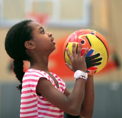 Fifth-grader Haset Lidetu shoots hoops Oct. 23 while wearing a Sqord band on her right wrist during her physical education class in Everett. (Associated Press)