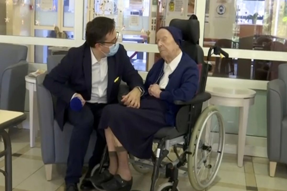In this image made from BFM TV video, Sister Andre, born Lucile Randon, is interviewed by David Tavella, Communications Manager for the Sainte Catherine Laboure Nursing Home in Toulon, France, Tuesday Feb. 9, 2021. The nun is the second-oldest known living person in the world, according to the Gerontology Research Group, which validates details of people believed to be aged 110 or older. French media report that the nun tested positive for COVID-19 virus in mid-January but just three weeks later she is fit as a fiddle — albeit it in her regular wheelchair.  (TEL)
